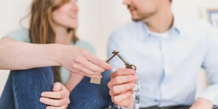 un couple tenant les clés de leur bien immobilier