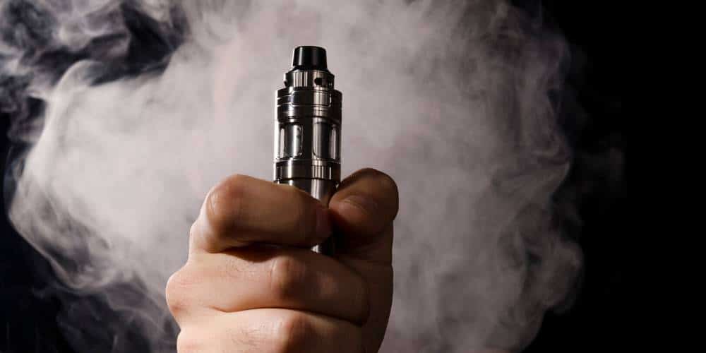 Vapoteur utilisant une e-cigarette dans un café