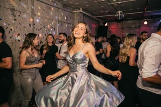 Jeune femme dansant avec énergie dans un club underground, robe satinée scintillante, atmosphère nocturne festive