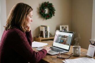 Femme consultant un site web d'opticien sur son ordinateur portable avant les fêtes de fin d'année