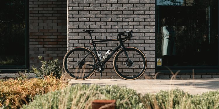 black and gray mountain bike beside brown brick wall