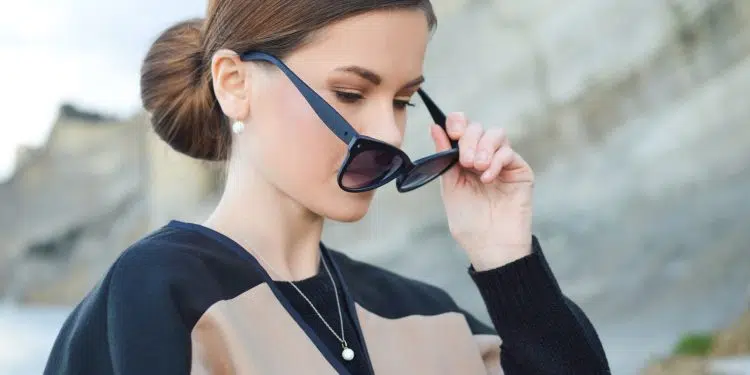 woman holding her black sunglasses